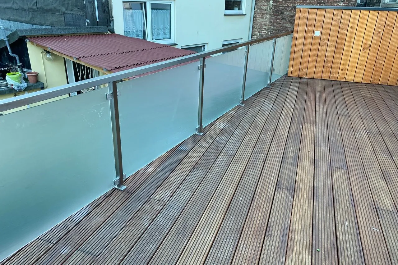 Balkon mit Milchglas-Geländer und Holzdeck