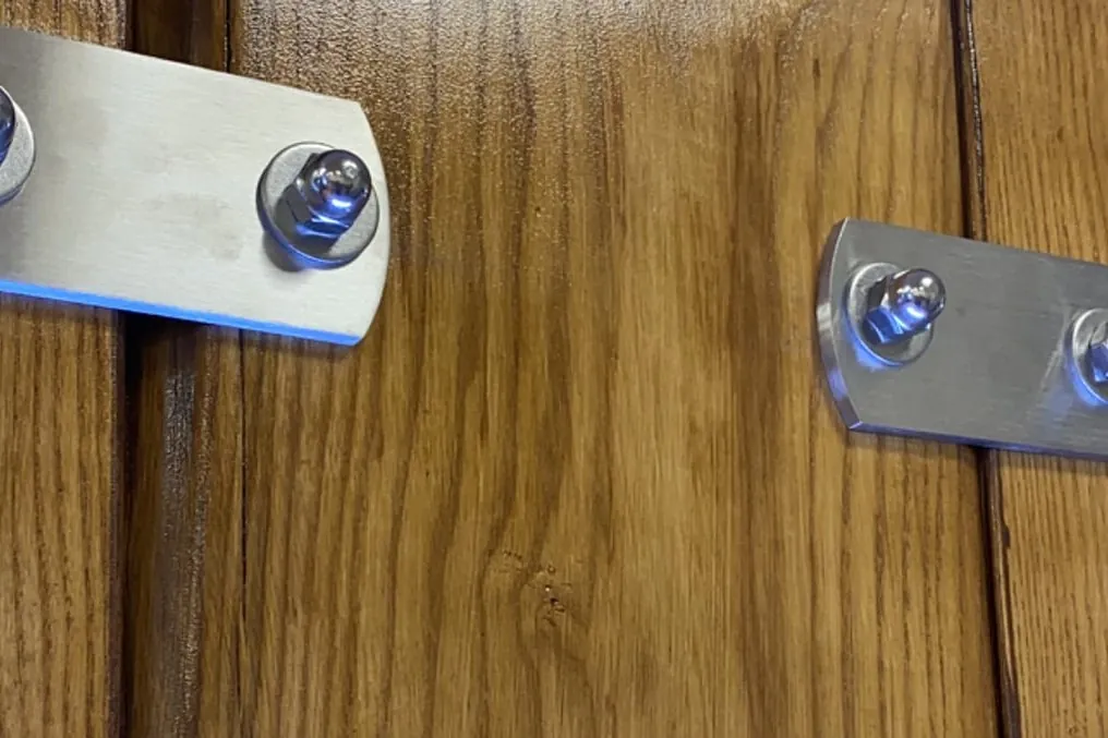Detail einer maßgefertigten Beschlaglösung auf Holz verschraubt