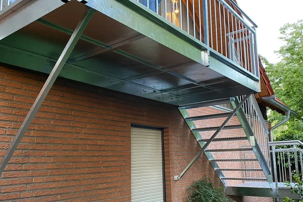 Metallbalkon mit Außentreppe an einem Klinkerhaus